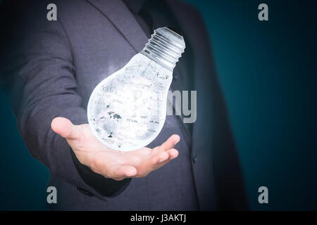 man showing creative business strategy with light bulb as concept, double exposure with technology background. Stock Photo