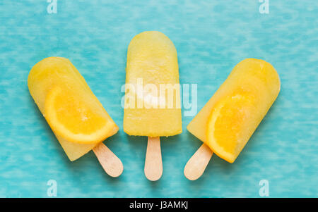 Fruit ice cream lollies on a blue surface. Top view, copy space Stock Photo
