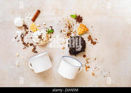 Scoops of ice cream in a variety of delicious and ingredients with two enamel mugs, flat lay Stock Photo