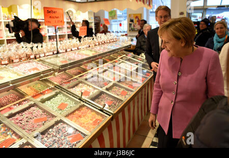 Eckernforde, Germany. 05th May, 2017. German Chancellor Angela Merkel walks through a candy factory before a CDU campaign event in in Eckernforde, Germany, 05 May 2017. Behind her is the CDU's lead candidate for the 07 May Landtag (state parliament) election, Daniel Gunther. Photo: Carsten Rehder/dpa/Alamy Live News Stock Photo