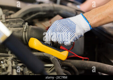 auto mechanic man with multimeter testing battery Stock Photo