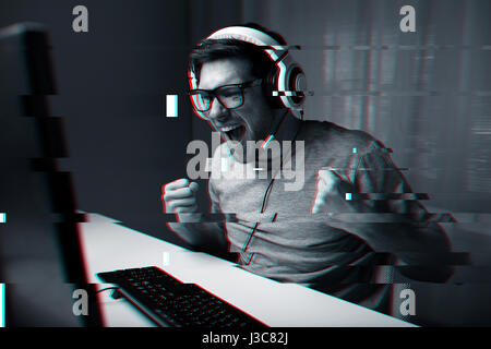 man in headset playing computer video game at home Stock Photo