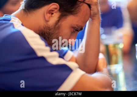 close up of sad football fan at bar or pub Stock Photo