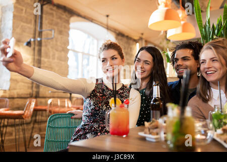 friends taking selfie by smartphone at bar or cafe Stock Photo