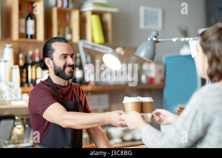 man or waiter serving customer in coffee shop Stock Photo