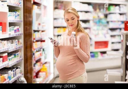 happy pregnant woman with medication at pharmacy Stock Photo