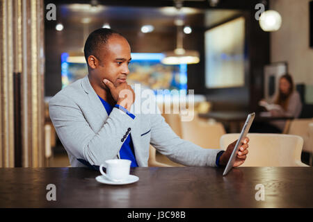 Image of happy young man using digital tablet in cafe Stock Photo