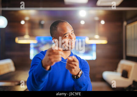 young attractive black student man with headphones and mobile phone listening to music dancing and singing the song happy and excited having fun isola Stock Photo