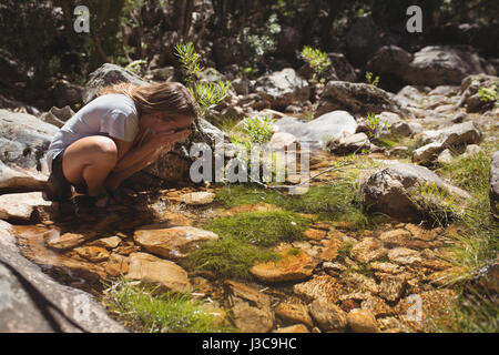 Women washing her face with a water on a sunny day Stock Photo