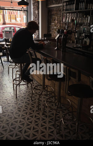 Silhouette of man using digital tablet at bar counter Stock Photo