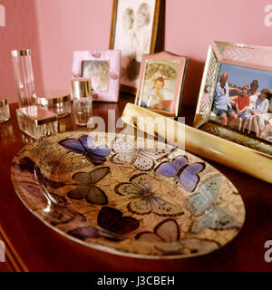 Perfume bottles and family photograph with butterfly dish Stock Photo