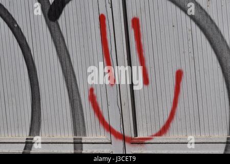 Drawn smiley peaking on the metal background Stock Photo