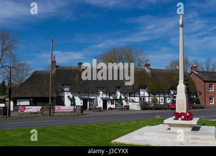 The Crown Inn ,a typical thatched roof pub and War Memorial in the village of King's Somborne, Hampshire, England. Stock Photo