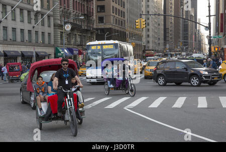 Pedicab with passengers enters Central Park from 6th Avenue in Manhattan, New York City. Stock Photo