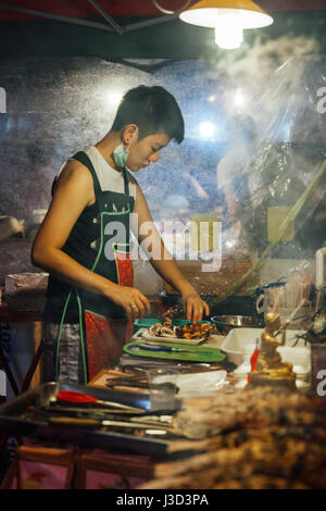 CHIANG MAI, THAILAND - AUGUST 27: Food vendor cooks fish and seafood at the Saturday Night Market (Walking Street) on August 27, 2016 in Chiang Mai, T Stock Photo