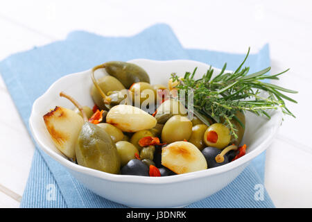 bowl of pickled olives, capers, caper berries and garlic Stock Photo