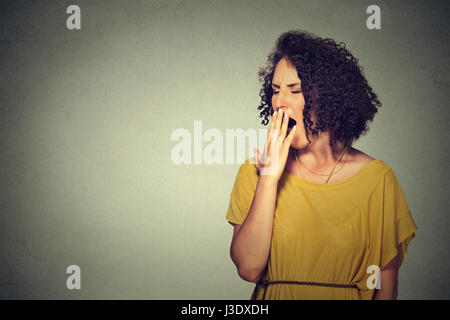 It is too early for meeting. Closeup portrait sleepy young woman with wide open mouth yawning eyes closed looking bored isolated grey wall background. Stock Photo