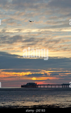 Beautiful Sunset. Evening Sky. Seagull over Worthing Pier. Gull flying over Sussex Landmark, UK Stock Photo