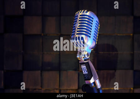 MINSK, BELARUS - SEPTEMBER 29, 2015: Silver old fashioned stage microphone- SHURE Super 55 Deluxe against wood background. Room for sound recording co Stock Photo