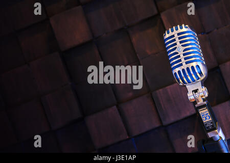 MINSK, BELARUS - SEPTEMBER 29, 2015: Silver old fashioned stage microphone- SHURE Super 55 Deluxe against wood background. Karaoke, vocal learning, mu Stock Photo