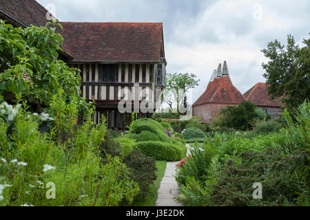 Gabled front of Great Dixter Manor, East Sussex, UK, originally built circa 1450, with oast houses beyond Stock Photo