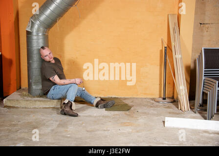 Young gay man wearing jeans and a top inside a room Stock Photo