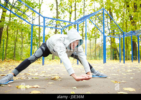 Doing Stretching Exercises in Park Stock Photo