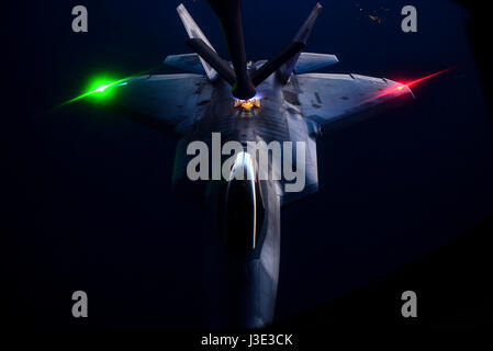 A USAF F-22 Raptor stealth tactical fighter aircraft refuels from a KC-135 Stratotanker aerial refueling aircraft at night over the Nellis Air Force Base Nevada Test and Training Range during the U.S. Air Force Weapons School Deliberate Strike Night June 16, 2016 near Las Vegas, Nevada.    (photo by Kevin Tanenbaum /US Air Force  via Planetpix) Stock Photo