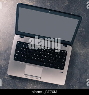 Overhead shot of modern laptop on dark table Stock Photo