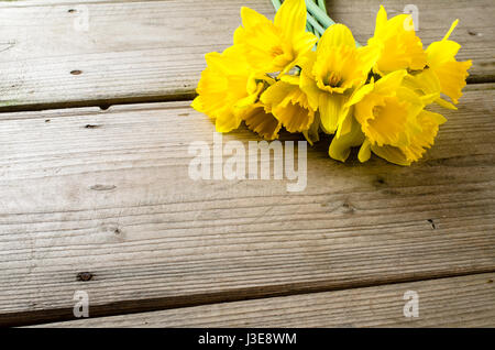 Yellow daffodils on wooden table Stock Photo