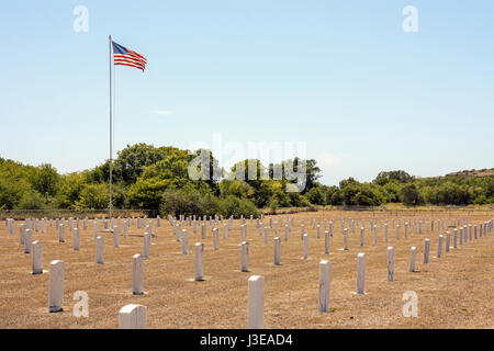 Headstones line the Cuzco Wells cemetery in Guantanamo Bay, Cuba while a United States flag flies in the background Stock Photo