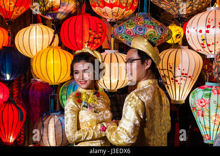 Hoi An, Vietnam - march 11 2017: vietnamese brides in traditional costume against colorful lanterns, Full Moon festival night Stock Photo