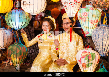 Hoi An, Vietnam - march 11 2017: vietnamese brides in traditional costume against colorful lanterns, Full Moon festival night Stock Photo