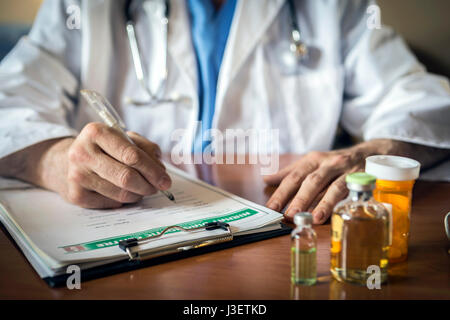 Doctor writing patient notes on a medical examination or prescription Stock Photo