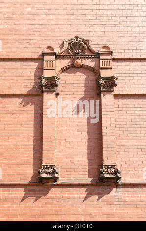 Ornate red brick decorative arch on a brick wall Stock Photo
