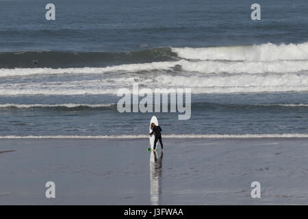 Surfer standing with surfboard waiting for waves in San Sebastian beach (Guipuzcoa, Spain) 2017. Stock Photo