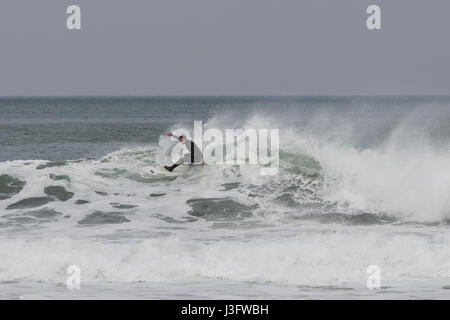 One surfer riding a wild wave full of foam in la Zurriola beach in San Sebastian (Guipuzcoa, Spain) 2017. Stock Photo
