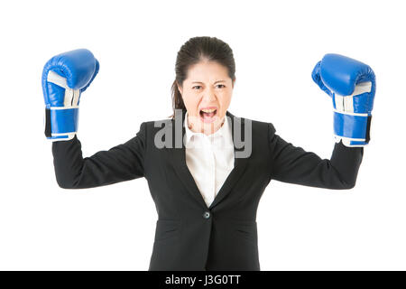 Boxing gloves business woman angry showing aggressive female businessperson flexing muscles wearing boxing gloves isolated on white background. young  Stock Photo