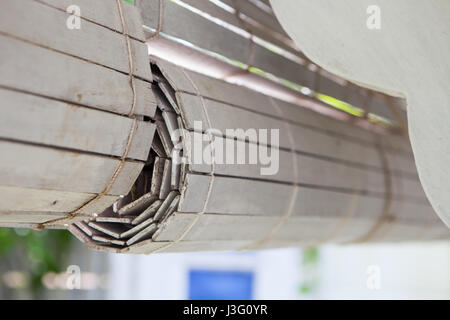 White rolled-up wooden blinds hanging outside houses Stock Photo