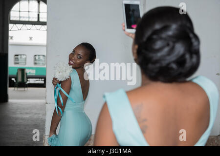 Bridesmaids pose for photographs at the Maputo railway station Caminho de Ferro de Mocambique designed by the architect Alexandre Gustav Eiffel Stock Photo