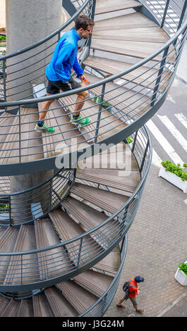 Man climbig a metal spilar stair case Stock Photo