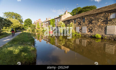 Leeds, England - June 30, 2015: A cyclist rides on the towpath alongside the Leeds and Liverpool Canal at Rodley in Leeds, West Yorkshire. Stock Photo