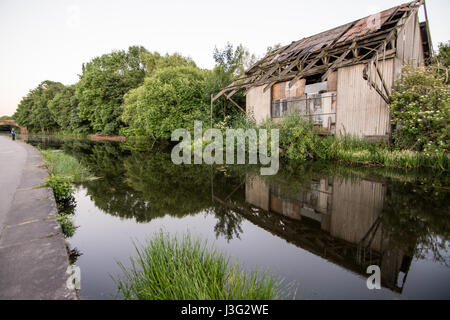 A derelict industrial warehouse beside the Leeds and Liverpool Canal in the Aire Valley of West Yorkshire, England. Stock Photo