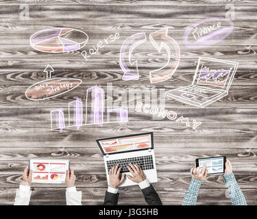Group of three people with devices in hands working together as symbol of networking and communication Stock Photo