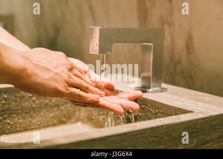 Man washing hands in public restroom. Modern WC sanitary or hygienic healthy lifestyle concept Stock Photo