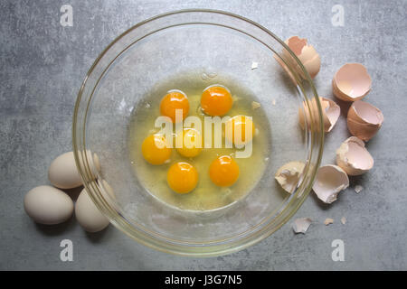 Raw eggs in glass bowl on kitchen table. Preparation of omelet Stock Photo