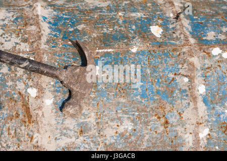 Rusty Metal Hammer on Old Barrel Peeled Paint for Use As a Texture or Background. Stock Photo