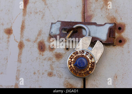 A rusty combination lock sitting unlocked. Stock Photo