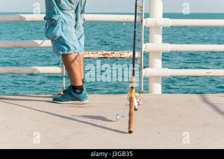 A Man Putting His Fishing Rod on the Ground and Waiting for fishes Stock Photo