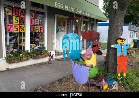 Decorative metal rooster and scarecrow lawn ornaments in front of an urban farm shop. St Paul Minnesota MN USA Stock Photo